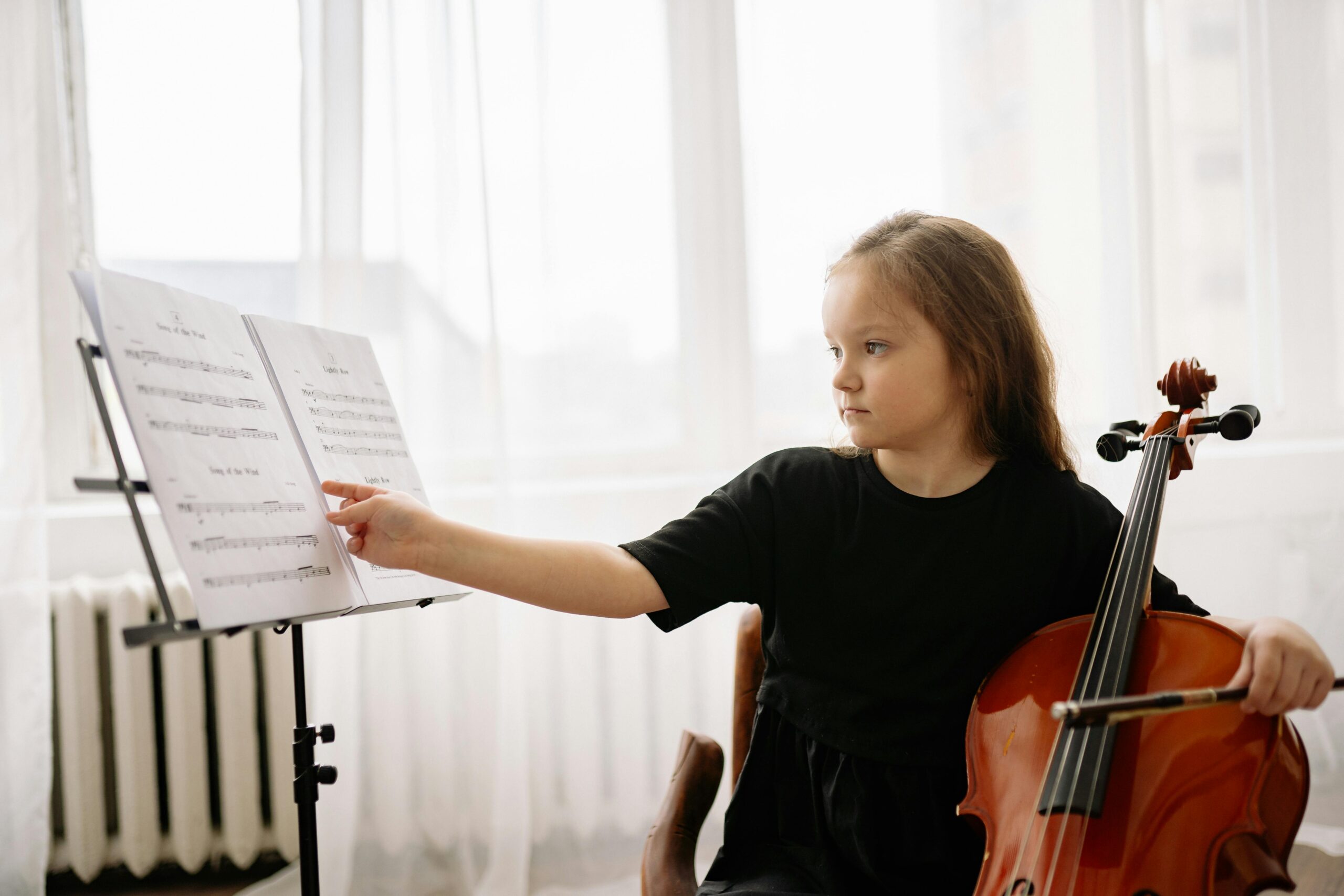 A teacher at The Music Workshop explaining a musical concept to a child who is listening intently.